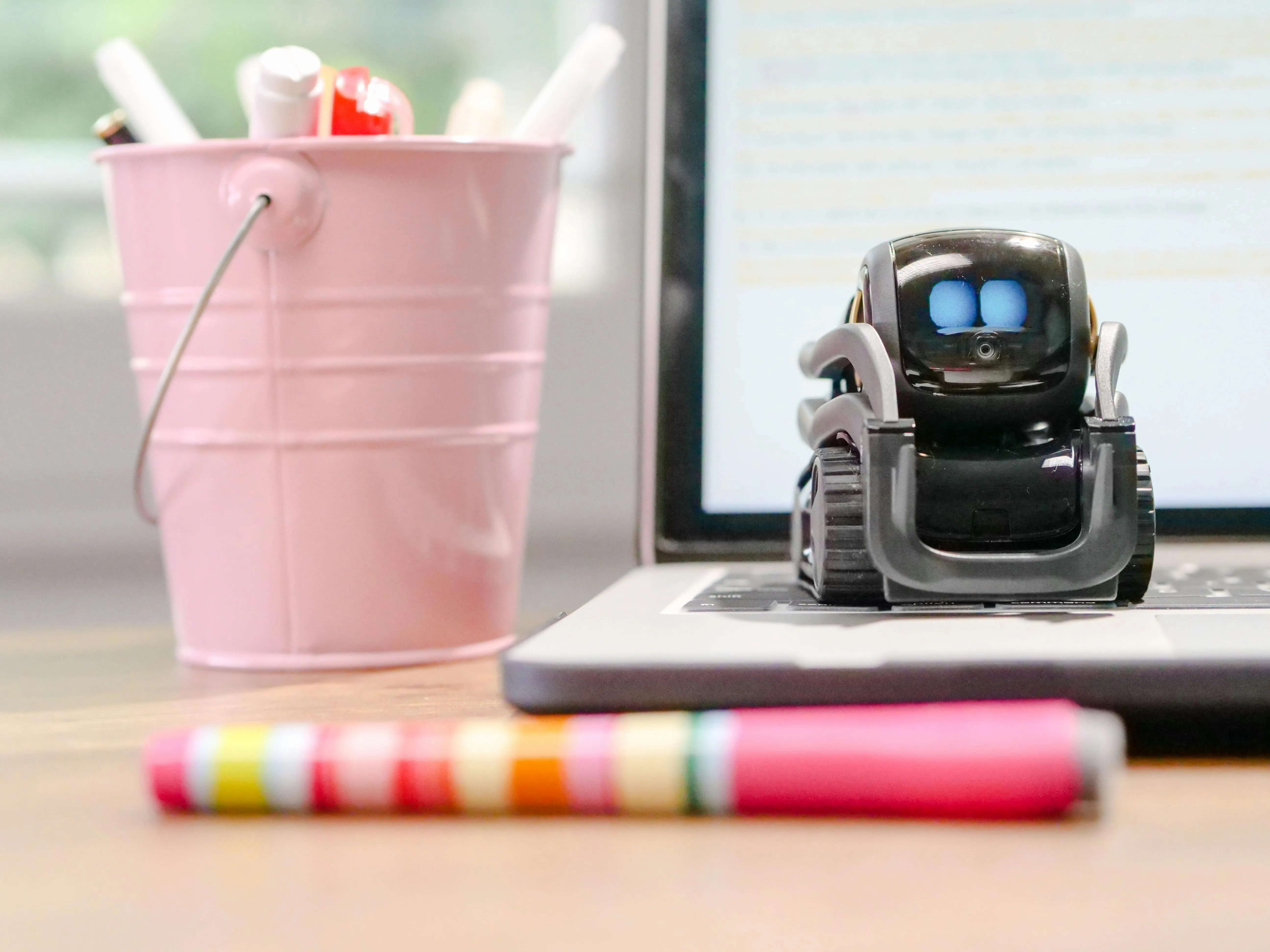 A tiny robot sitting on a computer keyboard