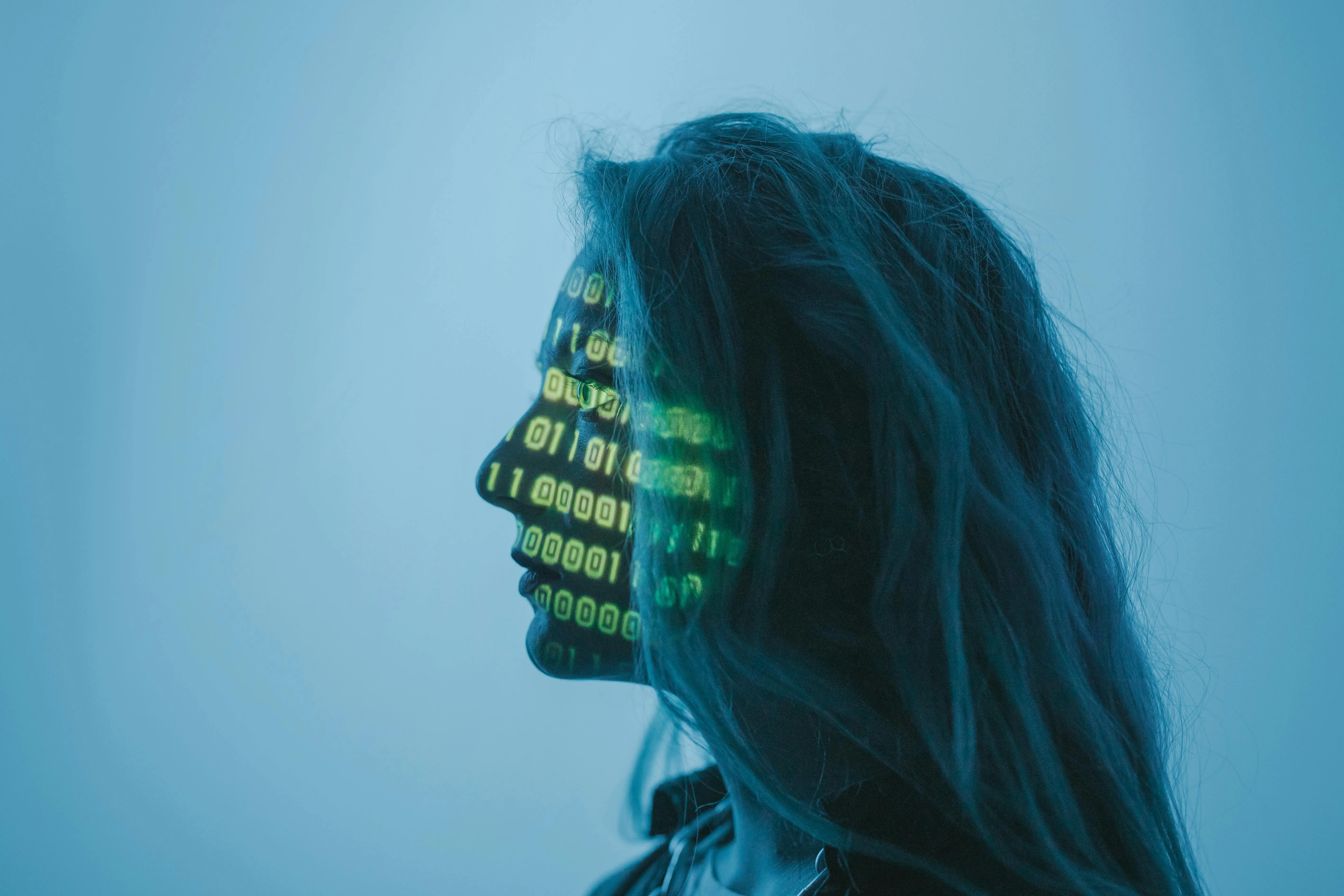 A woman whose face is covered in ones and zeroes
